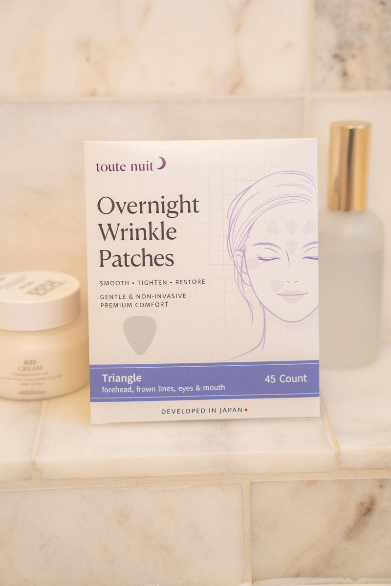 Toute Nuit Triangle pack beside skincare jars